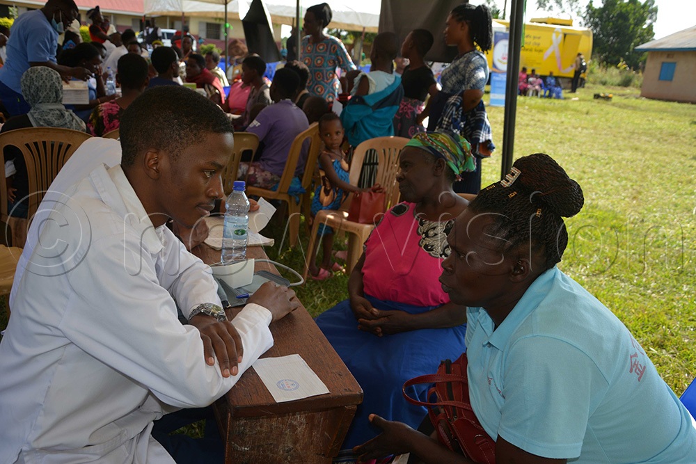 A medic listening to a woman who turned up for the medical camp in Kikuube district. (Photo by Peter Abaanabasazi)