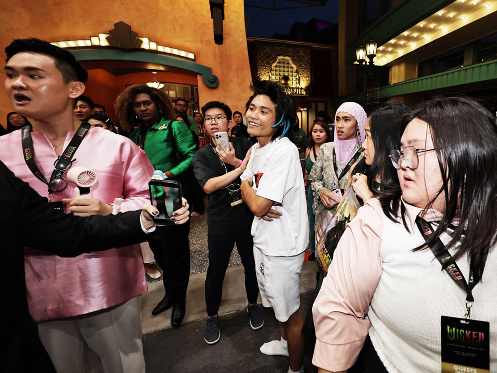 This picture by The Straits Times taken November 13, 2025 and provided on November 14 shows a man (C) accused of attacking pop star Ariana Grande at the premiere of the film "Wicked: For Good" in Singapore. (Credit: AFP)