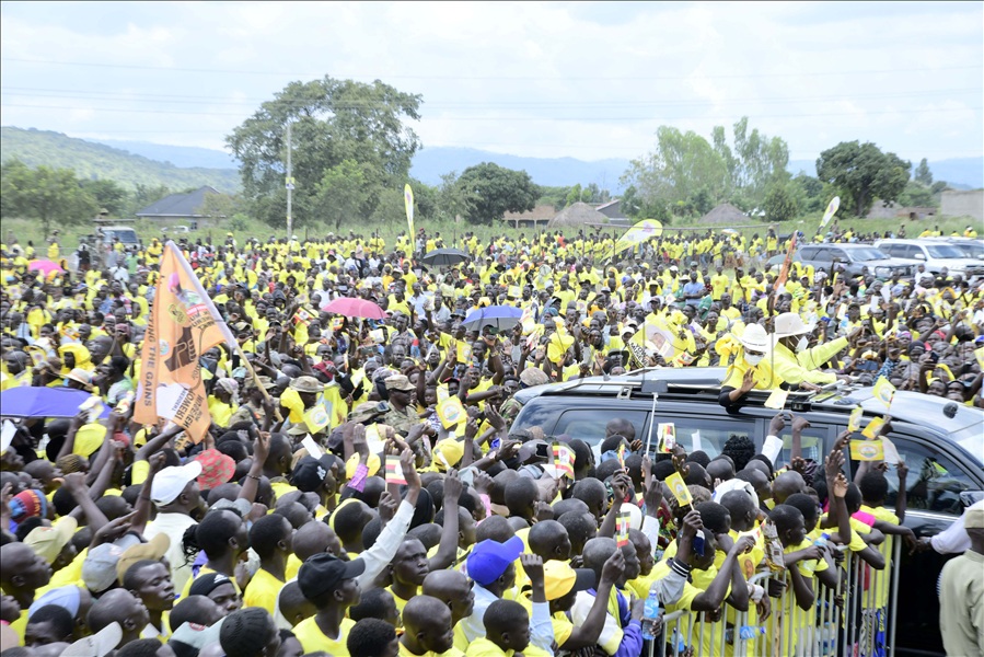 Museveni stood in his open-roof car with the First Lady, both waving and thumbing up to the yellow-donned cheering crowd.