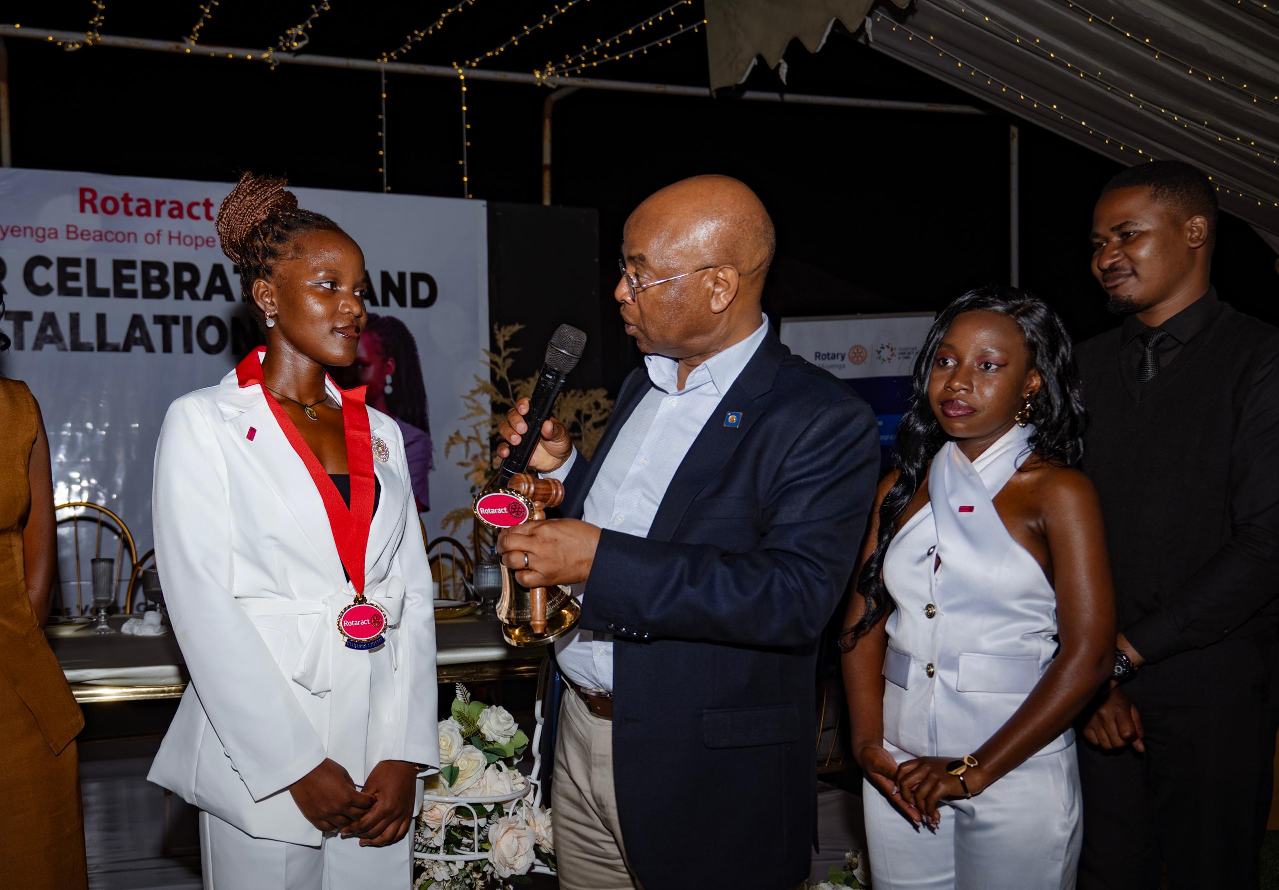 Deputy Governor of the Bank of Uganda, Prof. Augustus Nuwagaba installing Leticia Nakazibwe as the new club president. At his right is outgoing charter president Karungi Prettie Besigomwe. (Courtesy)