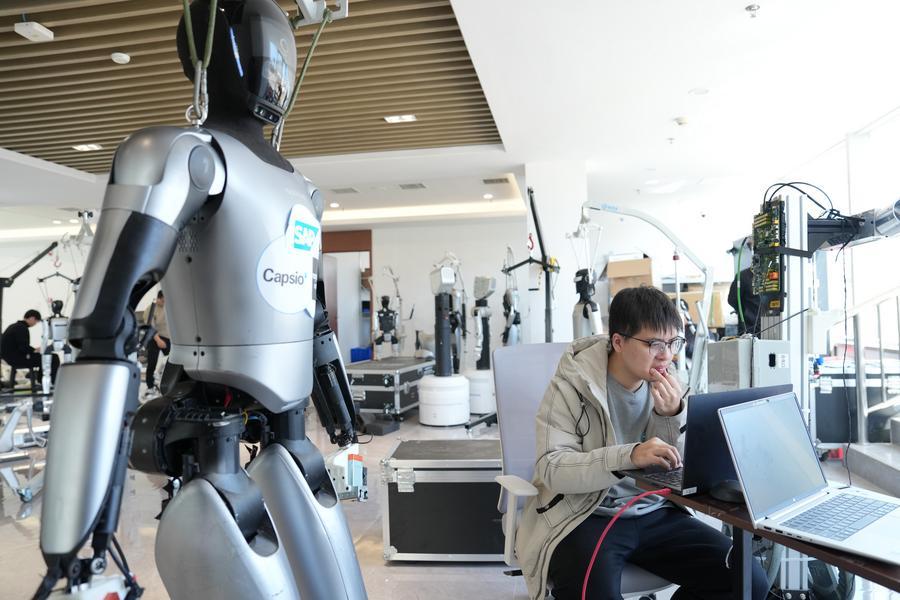 An employee tests a humanoid robot at MagicAtom in Suzhou, east China's Jiangsu Province, on March 10, 2026. (Xinhua/Li Bo)