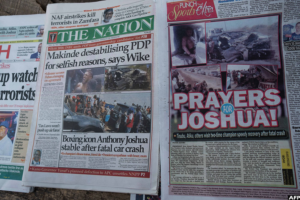 Newspapers bearing headlines about a road accident involving British boxer Anthony Joshua are displayed at a stall in Abeokuta, Nigeria on December 30, 2025. (AFP)