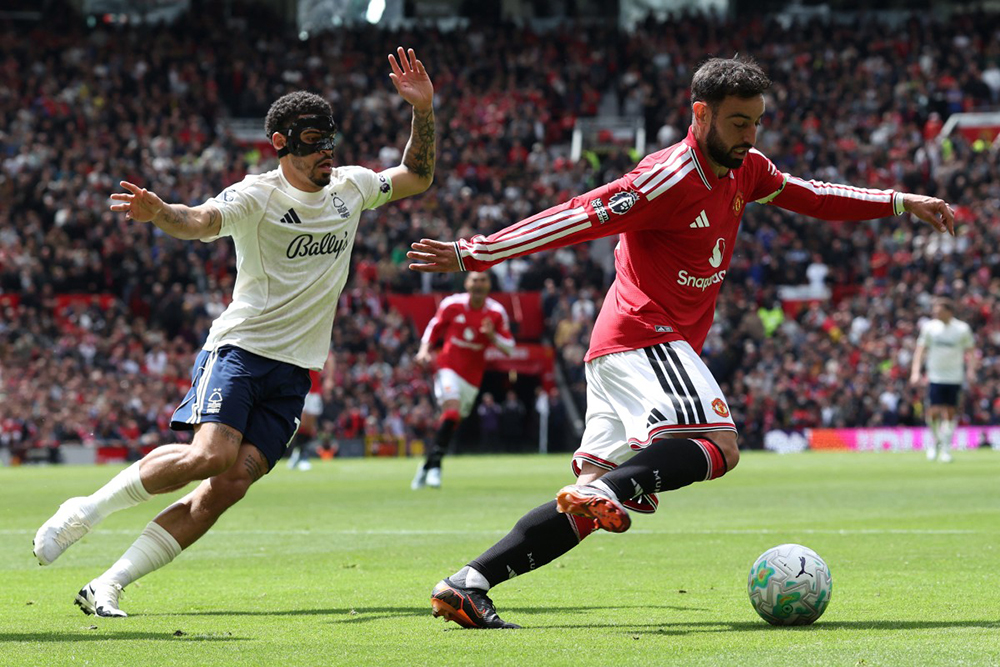 Manchester United's Portuguese midfielder #08 Bruno Fernandes (R) vies with Nottingham Forest's English midfielder #10 Morgan Gibbs-White (L) during the English Premier League football match between Manchester United and Nottingham Forest at Old Trafford in Manchester, north west England, on May 17, 2026. 