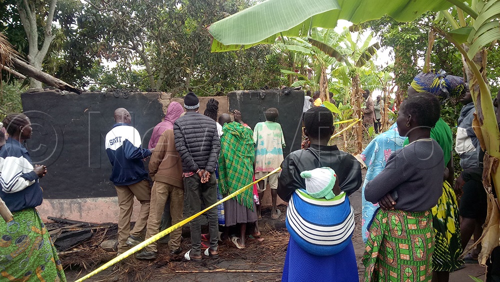 Neighbours gather at the razed home of the six family members. (Credit: Joel Akuma)