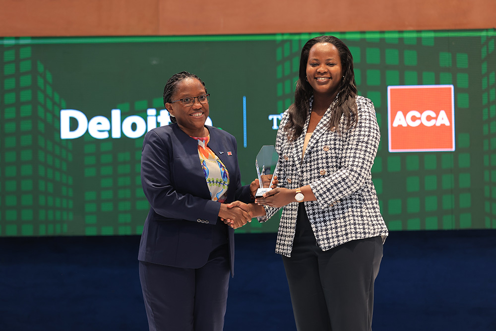 Kate Kiiza, the 2024 CFO Award winner hands Amanda Ayebare, CFO, AutoXpress Uganda Ltd the SME Award of the year. (Courtesy photo)