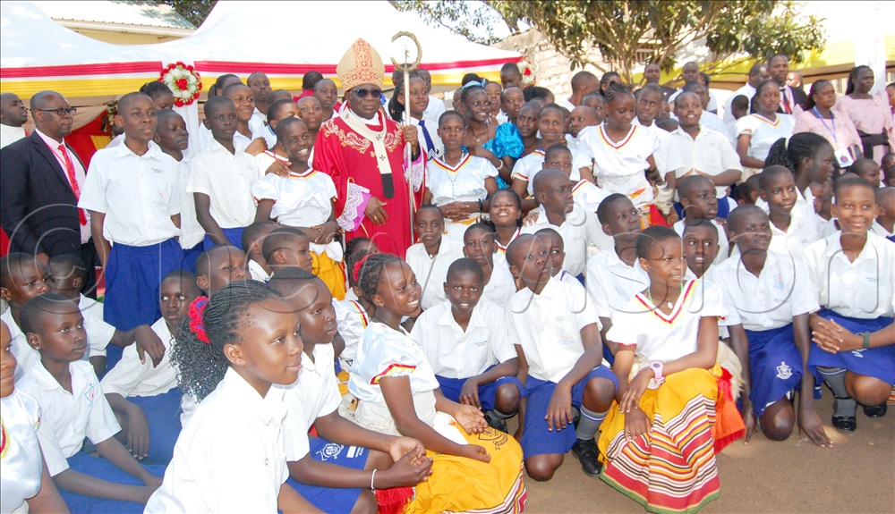 Archbishop Paul Semogerere shares a photo-moment with the musical ministers of St. Donozio Ssebuggwawo Boys PS Kisubi after the thanksgiving mass.
