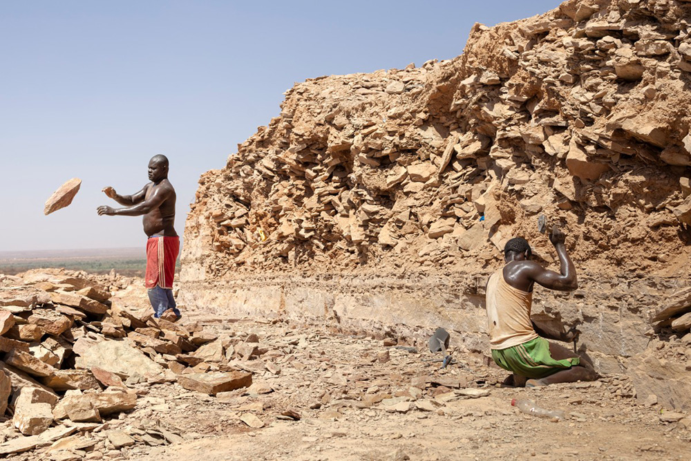Casual labourers at a quarry pile large stones hewn from bedrock for the construction industry in the hills outside Mandera town, where the highest infection rates of the parasitic disease Kala-Azar have been recorded, in Mandera, on January 22, 2026. (Photo by Tony KARUMBA / AFP)
