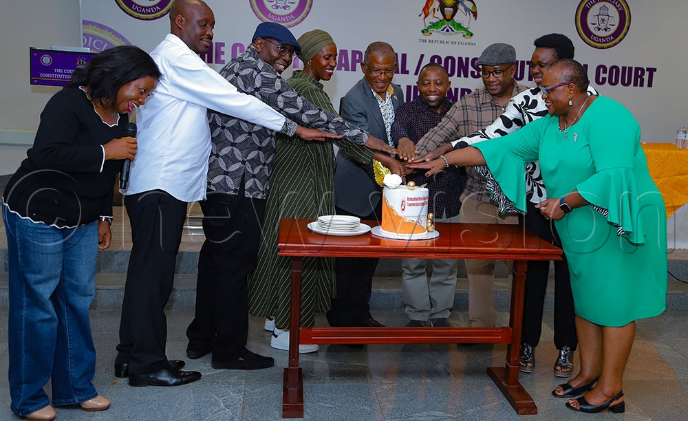 UJO-SACCO members cutting the cake after the AGM on Saturday May 30, 2026. (Credit: Farooq Kasule)