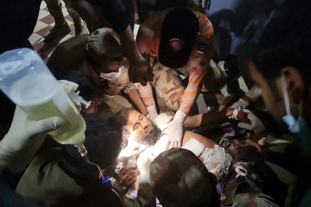 Paramedics treat an injured passenger at the Mach railway station, which has been turned into a makeshift hospital, after Pakistani security forces freed nearly 80 passengers following a security operation against armed militants who ambushed the train in the remote mountainous area, in Mach, southwestern Balochistan province on March 11, 2025. (AFP)