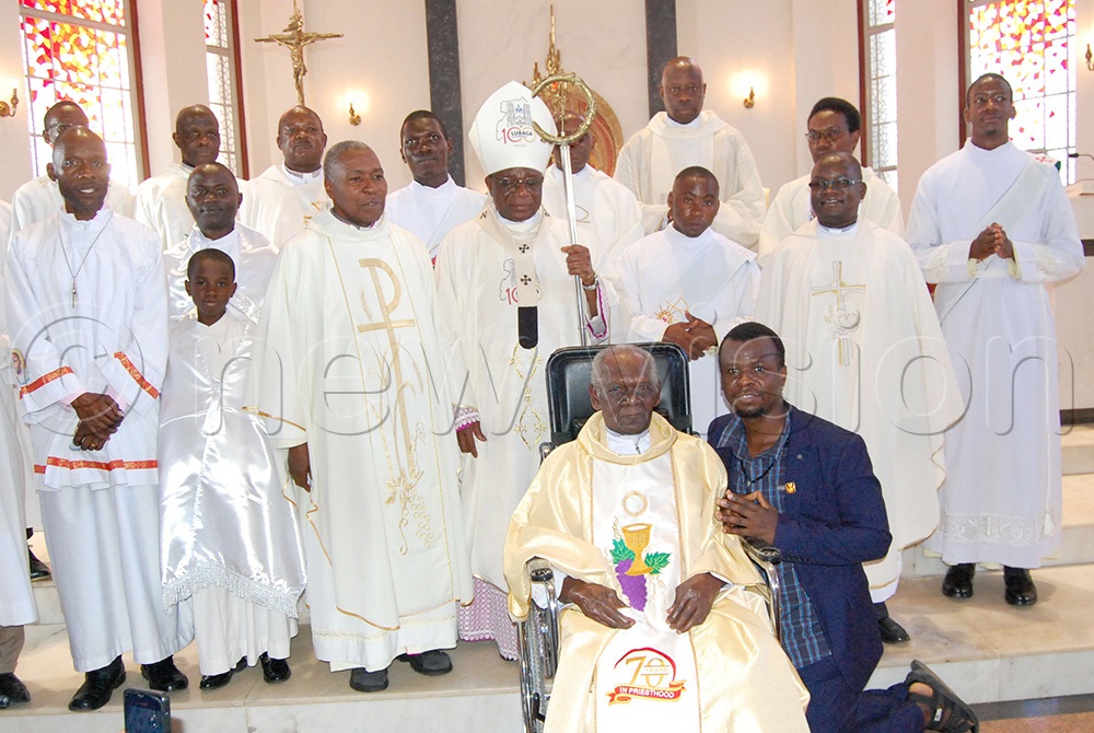 Msgr. Joseph Mugambe (seated) shares a photo moment with Archbishop Paul Ssemogerere (wearing a mitre), clerics and catechists during the thanksgiving mass for his 100th birthday and 70th priestly anniversary at Christ the King Church Kampala on Sunsday November 23, 2025. (Photo by Mathias Mazinga)