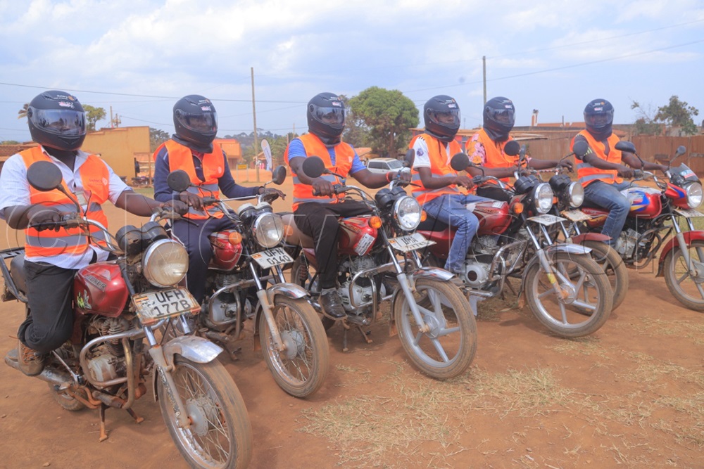 Some of the boda boda riders pose with the safety gear they received from the Rotary Club of Sonde beside their motorcycles. (Photo by Eric Yiga)
