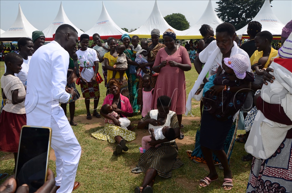 Local Artist Francis Angiro performing as women breastfeed their children on Thursday.