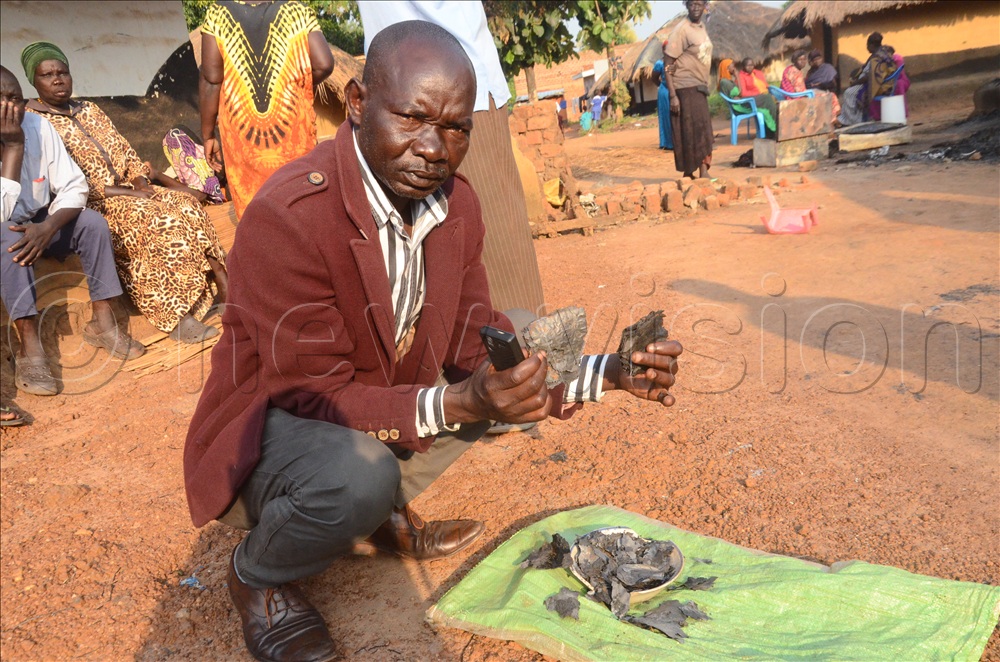 Ratib Moga Latigo, the chairperson of Takwa cell, showing ashes of the money burnt in the house.