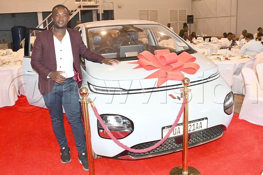 Moses Ssenyonjo stands besides his newly acquired  brand new Wuling Electrical Vehicle he won from the the second draw of the Linglong Tyres Electric Vehicle promotion at Mandela AutoZone in Industrial Area. Photo by Michael Nsubuga