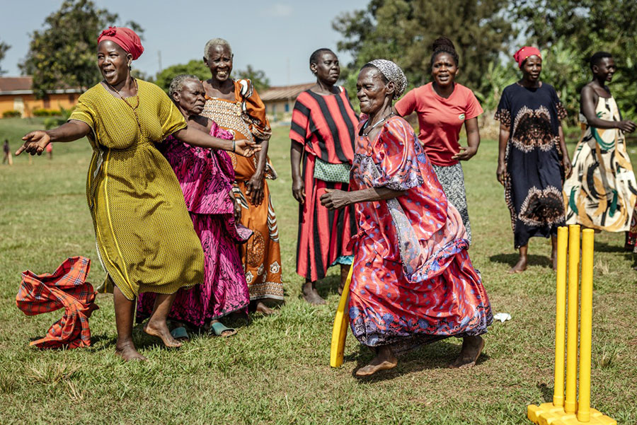 An elderly woman run between the wickets as others react during a cricket and physical training session in Jinja, on January 10, 2026. AFP PHOTO