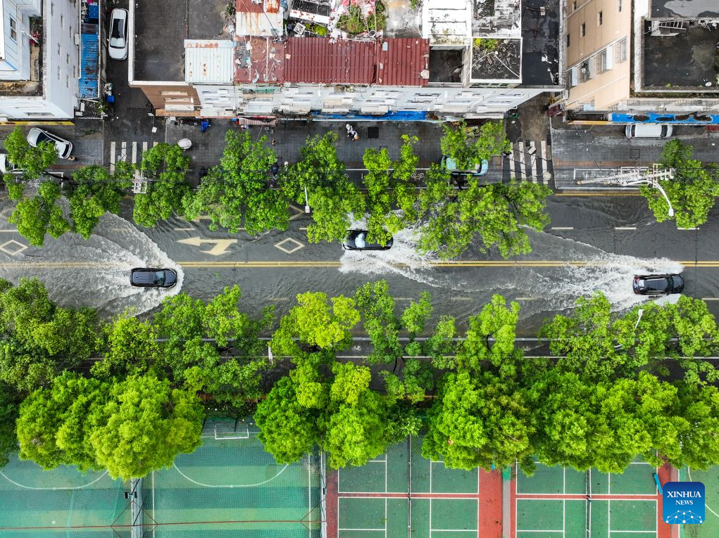 An aerial drone photo taken on July 12, 2026 shows cars moving on an inundated road in Yueqing City, east China's Zhejiang Province. 