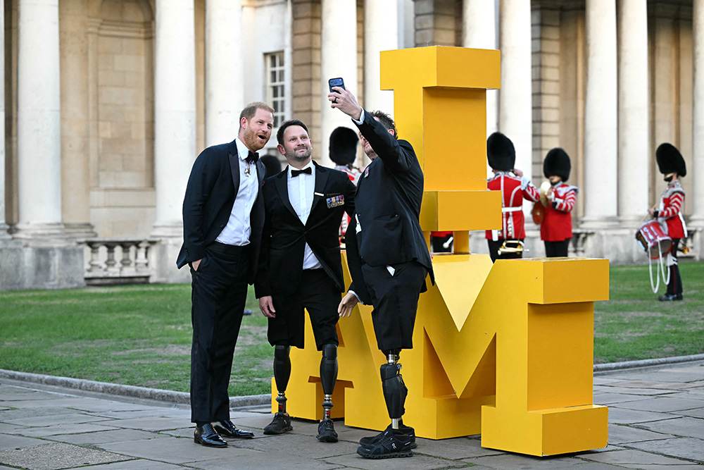 Britain's Prince Harry, Duke of Sussex (L) poses for a selfie photograph as he arrives to attend the inaugural Invictus Spirit Awards at the Old Royal Naval College in Greenwich, south-east London on September 17, 2026. (Photo by JUSTIN TALLIS / AFP)
