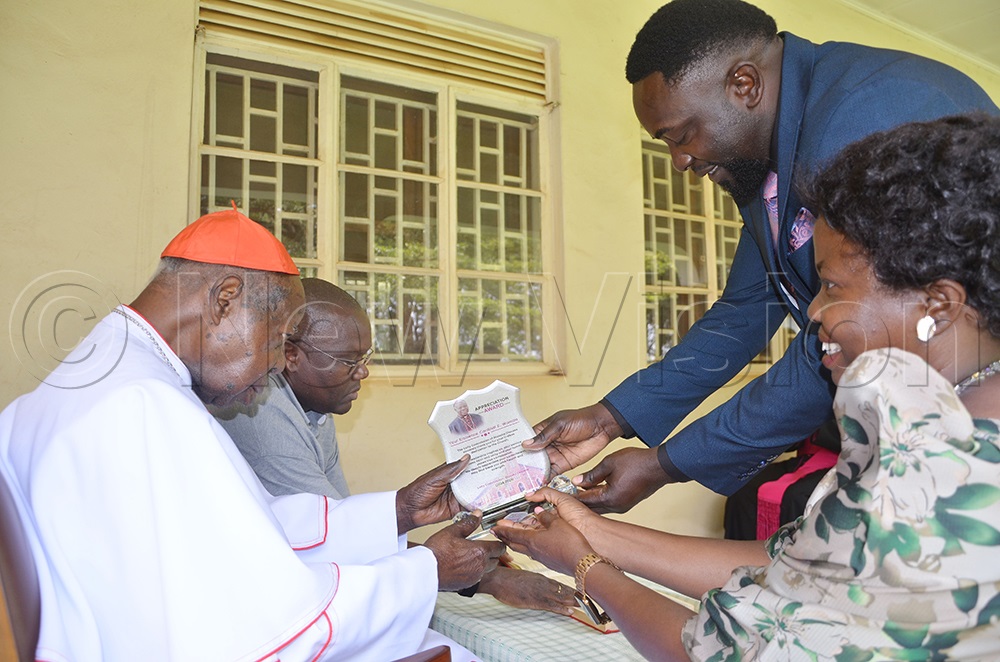 Emmanuel Cardinal Wamala receives award from Head of Laity of Masaka Diocese, Regina Nalubega Kittaka and council member as visiting him at residence on Wednesday August 27, 2025. (PHOTO BY JULIET ANNA LUKWAGO)