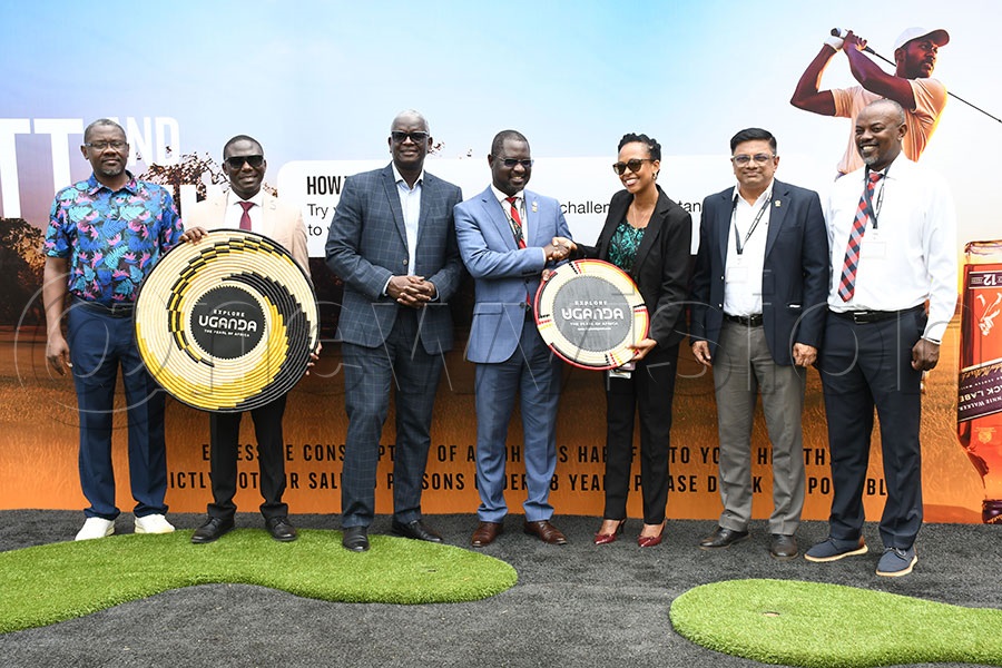 Uganda Tourism Board CEO Juliana Kaggwa (3rd right) hands over a craft to UGU president Jackson Were (centre) to signify their sponsorship to the Johnnie Walker Uganda Open Golf Championship, at UBL headquarters. Photo by Michael Nsubuga 