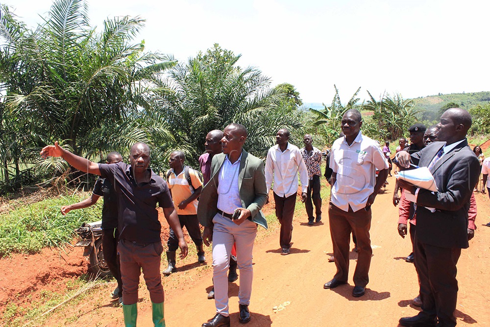  Buvuma Grade 1 Magistrate, Johnson Talemwa (right), head of NFA Buvuma sector, Wilfred Tumwesigye (second right), Godfrey Galiwango (right) as he took the magistrate around his land which NFA contests that its forest reserve. (Photo by Henry Nsubuga)