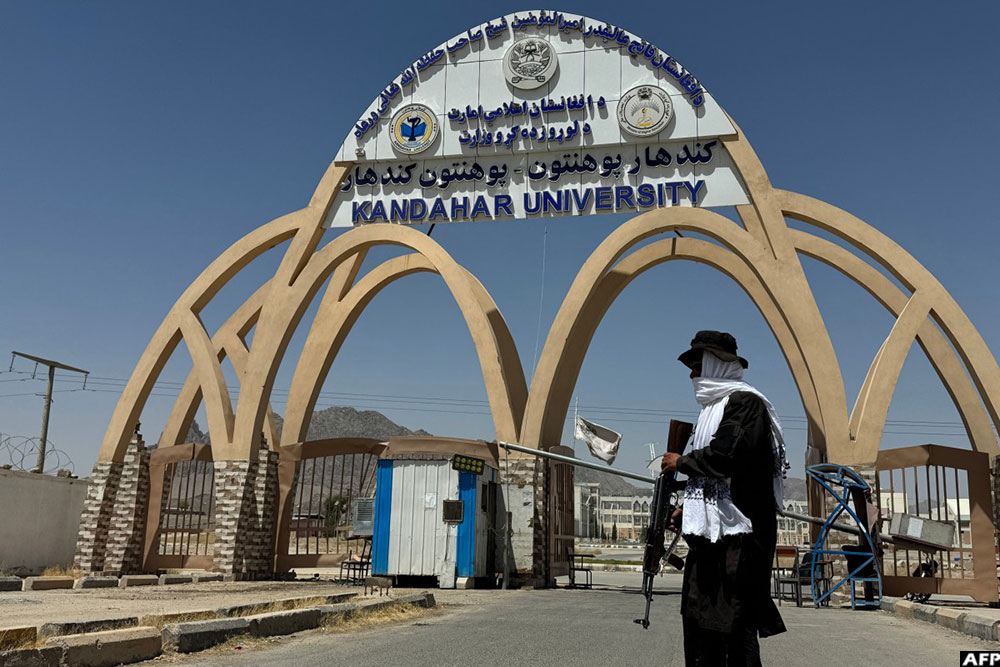 A Taliban security personnel stands guard at an entrance gate of Kandahar University in Kandahar on August 12, 2026