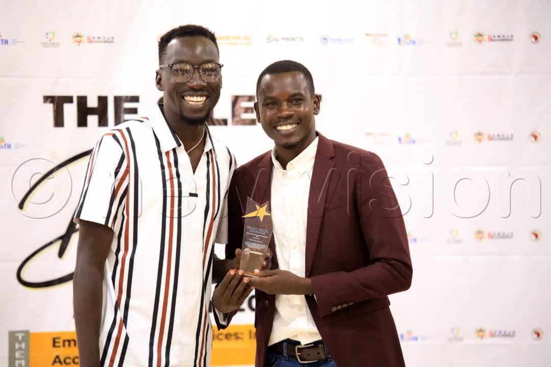 Abel Odeke, the CEO of Equal Aqua Uganda (left), the guest of honor, rewards Kizito Anguzu for his outstanding contribution as a sign language interpreter. (Photo by Ritah Mukasa)