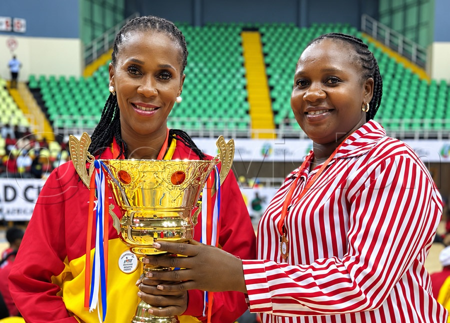 She Cranes assistant head coach Ruth Meeme (right) and She Cranes captain (left) pose for a photo with the Africa trophy they won in Nairobi