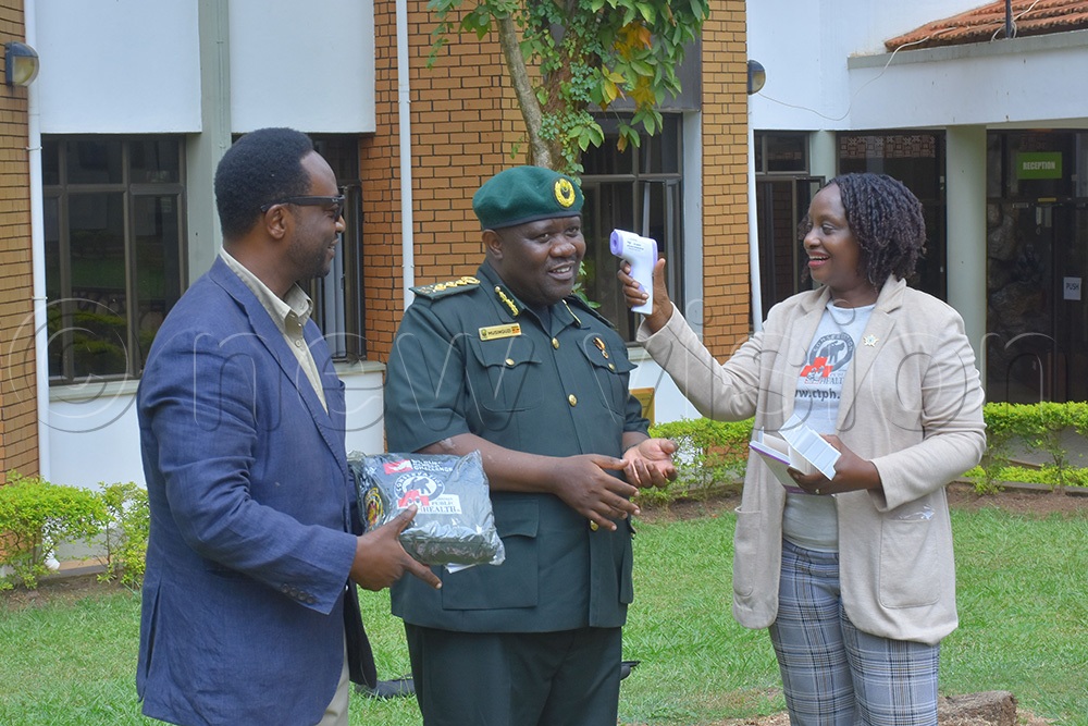 Dr. Gladys Kalema (right) with husband Lawrence Zikusoka (left) exhibiting how the infrared thermometers operate. The consignment consisted of 25 non-contact infrared thermometers that will be used by the UWA staff to measure temperatures of each tourist heading for gorilla and chimpanzee tracking. (Photo by Julius Luwemba)