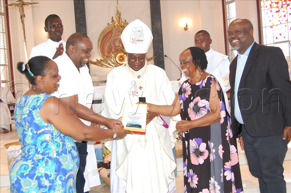 Family members receiving an accolade from Archbishop Paul Ssemogerere (centre).
