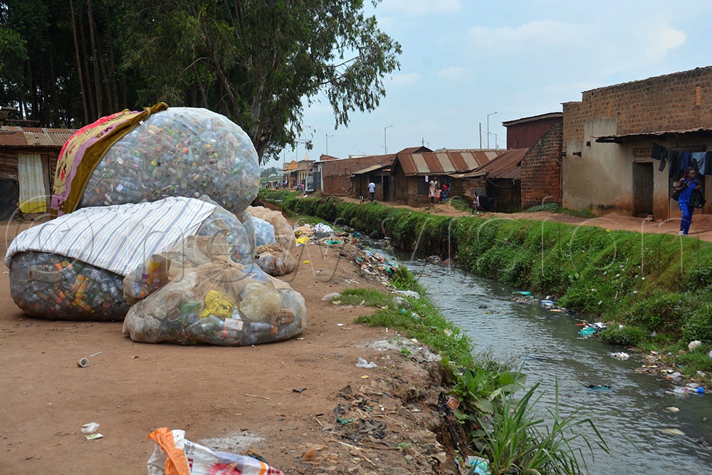  Heaps of plastic bottles placed near the drainage channel in a Kamwokya slum. (Photo by Francis Emorut)