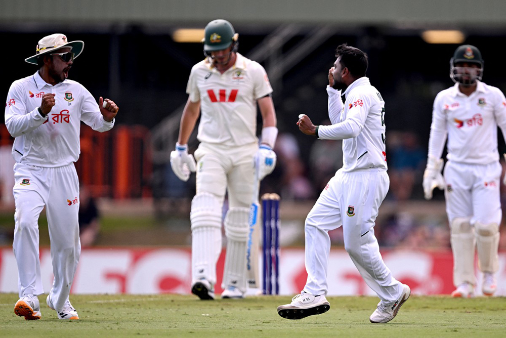 Bangladesh bowler Mehidy Hasan Miraz (2nd R) celebrates with teammate Najmul Hossain Shanto (L) after dismissing Australia's batsman Pat Cummins (2nd L) on the fourth day of the first cricket Test match between Australia and Bangladesh at Marrara Stadium in Darwin on August 16, 2026.