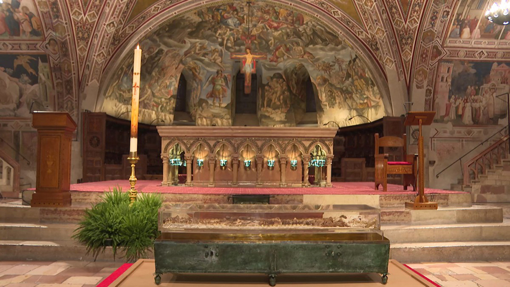 This video grab taken from an AFP shooting shows the remains of St. Francis of Assisi on display in a glass case inside the Basilica of St. Francis of Assisi during a press preview, in Assisi on February 21, 2026. The exposition to the public of the remains will begin on February 22 to mark the 800th anniversary of his death in 1226.