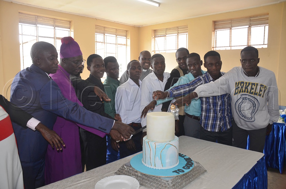 (L-R): Head teacher Mbarara High School Ham Ahimbisibwe, bishop of Ankole diocese, Rt. Rev. Fred Sheldon Mwesigwa, joining excellent performers of UACE exams 2025 for Mbarara High School in cutting cake as a sign of celebrating the milestone. This was shortly after a dedication service held at St James Cathedral-Ruharo in Mbarara City on Monday. (Credit: Abdulkarim Ssengendo)