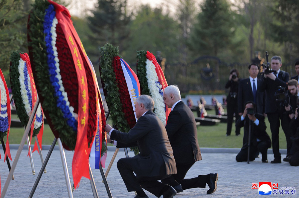 This picture taken on April 26, 2026 and released by North Korea's official Korean Central News Agency (KCNA) via KNS on April 27, 2026 shows Russian State Duma Speaker Vyacheslav Volodin (L) and Defence Minister Andrei Beloussov (R) laying wreaths at the memorial tower for fallen troops of the Korean People's Army's special operations at the Memorial Museum of Combat Feats at the Overseas Military Operations in Pyongyang. 