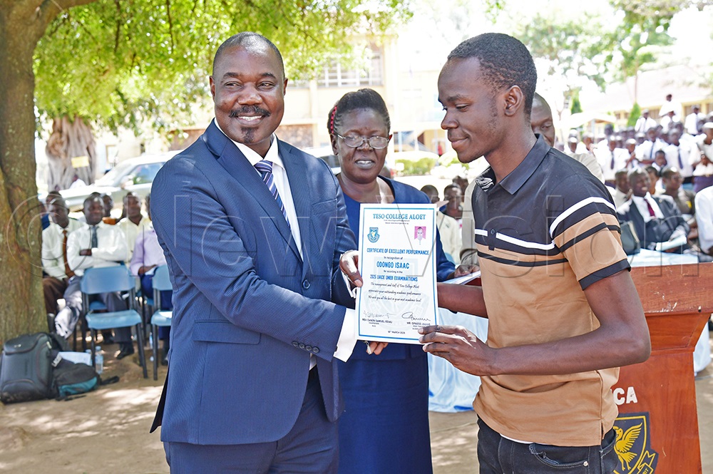 Triplet Isaac Odongo receiving his certificate from Soroti City East MP-elect Moses Okia Attan. (Credit: Godfrey Ojore)