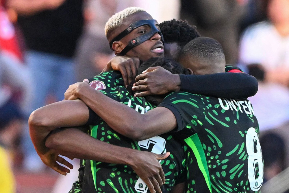 Nigeria's forward #09 Victor Osimhen celebrates his goal with teammates during the Africa Cup of Nations (CAN) quarter-final football match between Algeria and Nigeria at the Grand stadium in Marrakesh on January 10, 2026. (Photo by SEBASTIEN BOZON / AFP)
