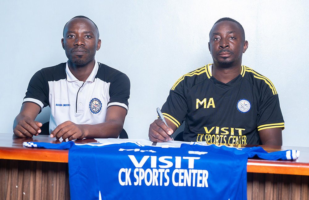 Bugema University sports manager Robinson Masereka (left) with new head coach Andrew Mugagga (right) after signing his contract. (Courtesy Photo)