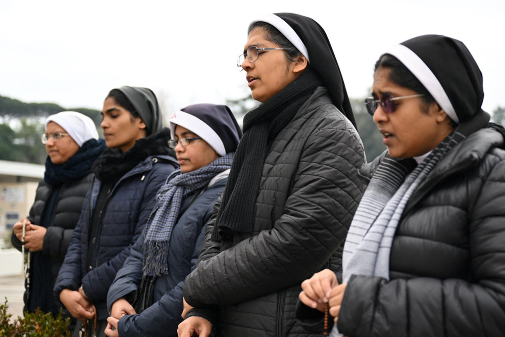 Nuns pray at the statue of John Paul II outside the Gemelli hospital where Pope Francis is hospitalized in Rome on February 24, 2025. (AFP)