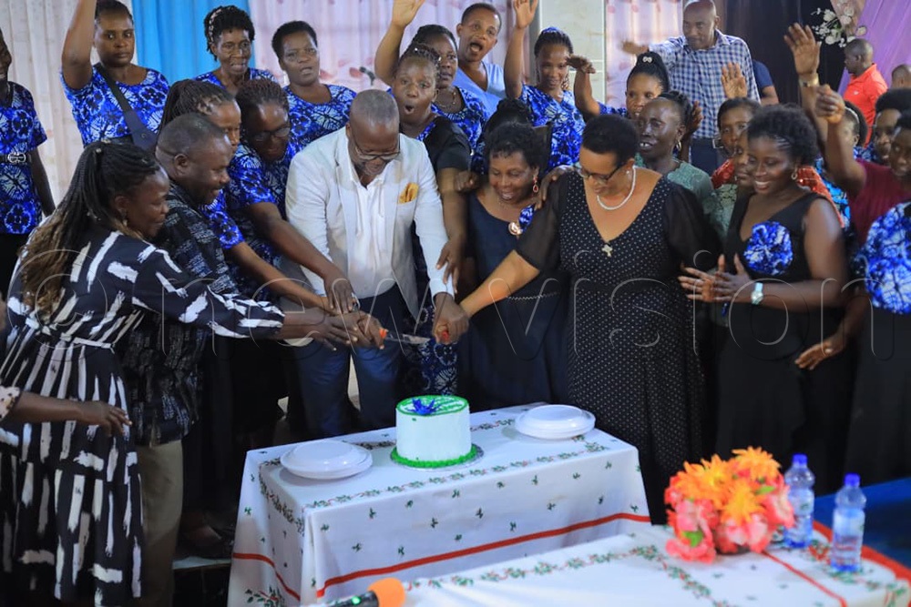 Rogers Byamukama MP-elect Masindi Municipality joined by women to cut the cake in commemoration of the International Women's Day. (Photo By Javier Silas Omagor)
