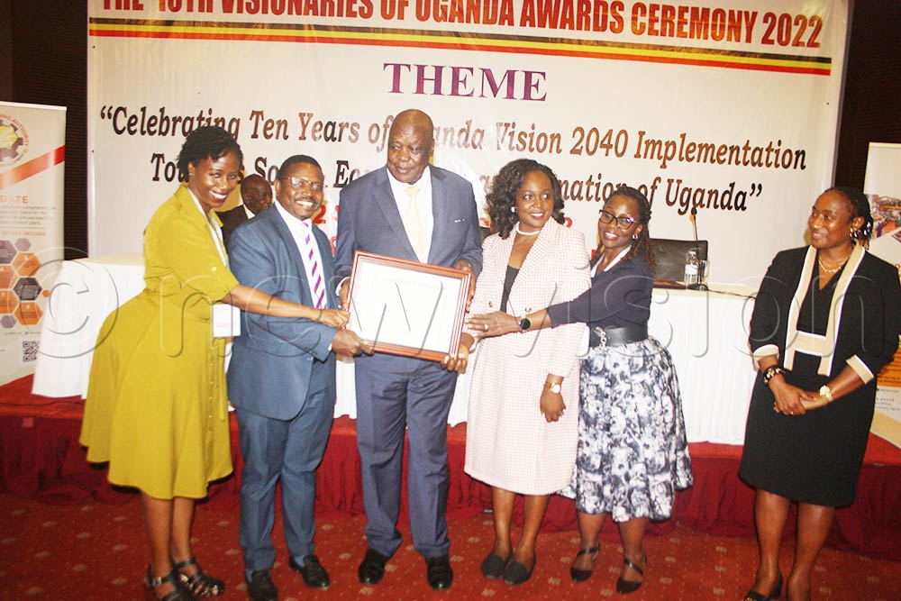 State Minister of Energy and Mineral Development Hon Peter Lokeris and the National Planing Authority Chairperson Prof. Pamela Mbabazi hand over certificate to service providers at the function. (All Photos by Isaac Nuwagaba)