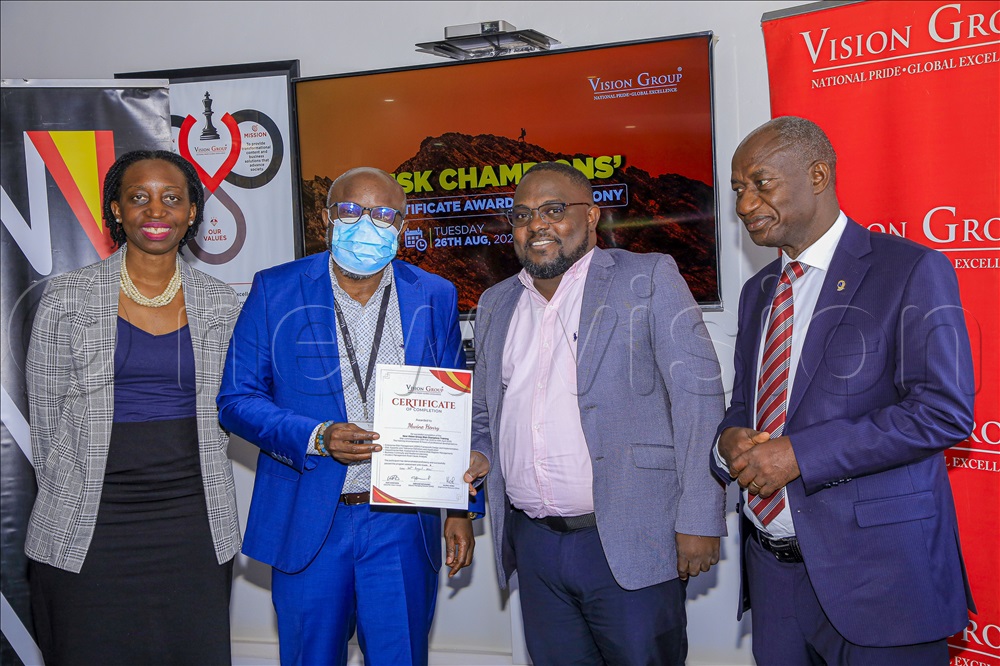 Vision Group Chief Executive Officer Don Wanyama (2nd left) handing over a certificate of completion to Henry Mwine, one of the risk champions for having completed a 6 week training. Looking on is the Deputy Managing Director Gervase Ndyanabo (1st right) and Chief Risk Officer Housing Finance Bank Marietta Naiga Matovu (1st left) This happened on 26th August 2025 at Vision Group Head Office. 