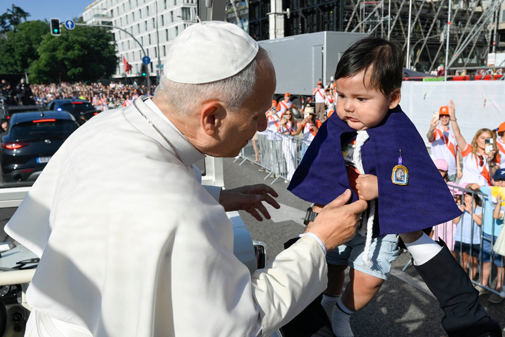 This handout photo taken and released on June 7, 2026 by The Vatican Media shows Pope Leo XIV looking at a baby as he arrives to lead the Holy Mass held in the Plaza de Cibeles in Madrid.
