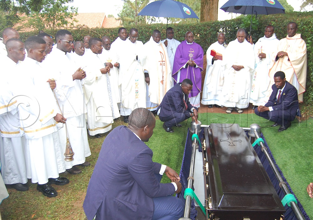 Catholic clerics and other mourners in a sombre mood as the casket of Bro. Joseph Muyunga is lowered into the grave. (Photo by mathias Mazinga)