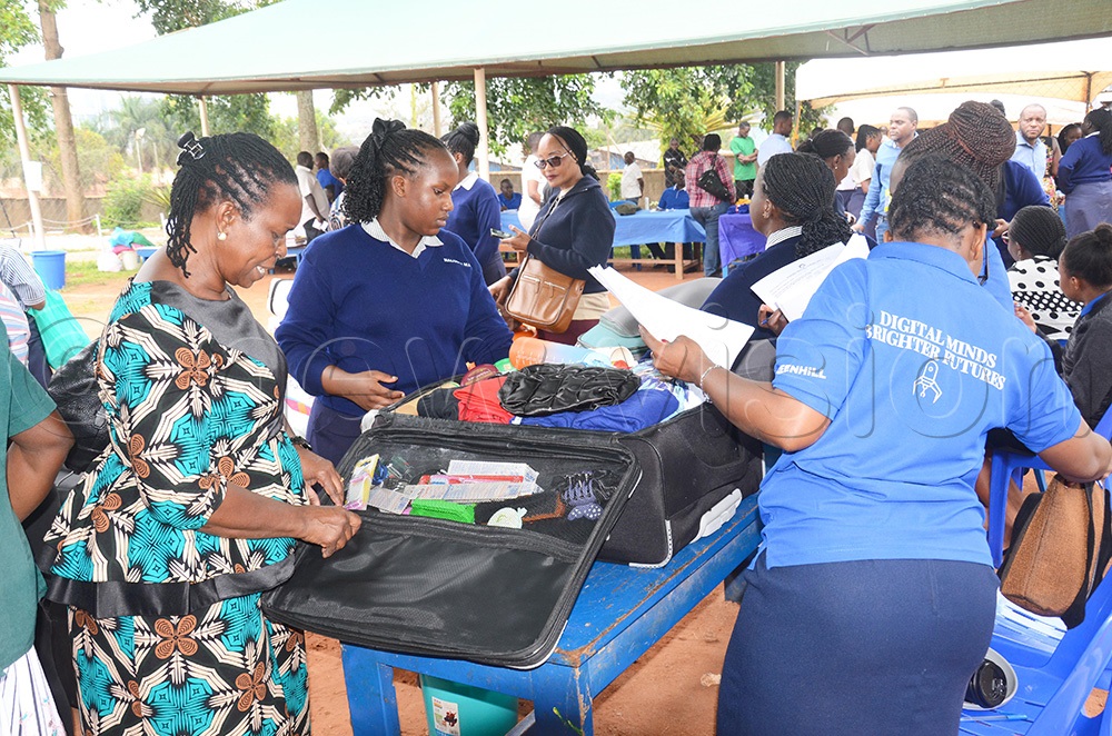 A Greenhill Academy matron checking a suitcase of a female learner at school premises in Kibuli Kampala during the opening day. (Photo by Isaac Nuwagaba)