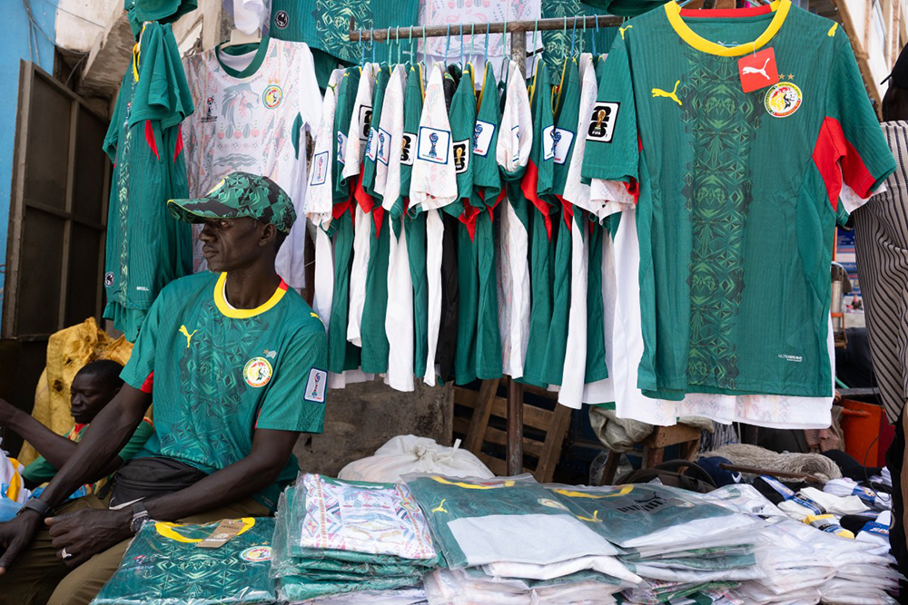 A vendor selling Senegalese football shirts sits at his stall in Dakar on June 11, 2026, ahead of the opening match of the 2026 FIFA World Cup football tournament. (AFP)