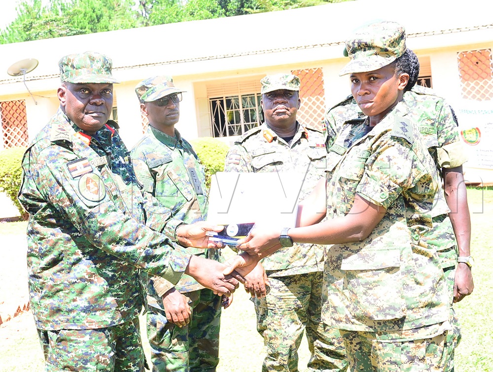 Karugaba (L) flanked by Ruzindana and others while awarding a gift and certificate to Lt Harriet Nabirye who was the overall student in basic medical logistics management course. (Photo by Jackie Nambogga)