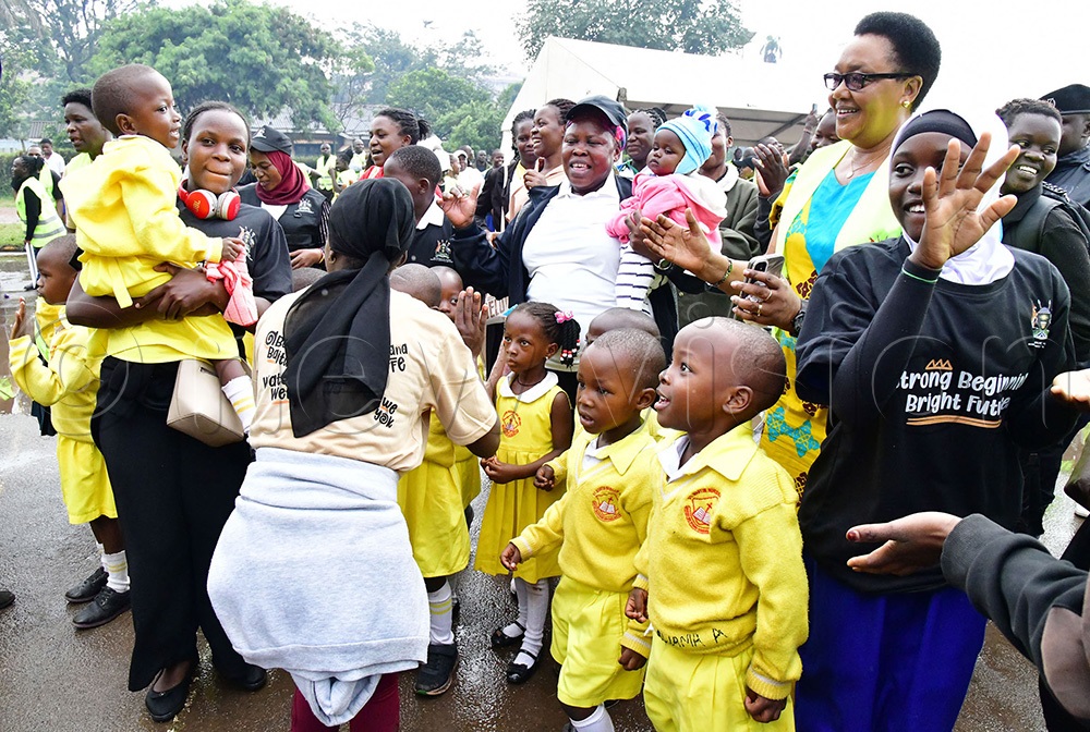 Dr. Joyce Kaducu Moriku, Minister of State for Primary Education (centre, carrying a baby) together with learners, teachers and other stakeholders  gearing up for National launch of the Early Childhood Care & Education (ECCE) 2025. (Photo by Mpalanyi Ssentongo)