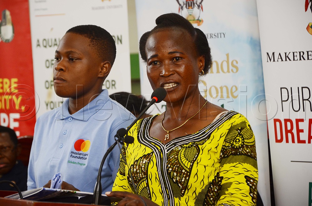 Agnes Nakayenga, from Kiboga district, addressing parents as her daughter looks on during the scholarship award ceremony at Makerere University. (Photo by Juliet Kasirye)