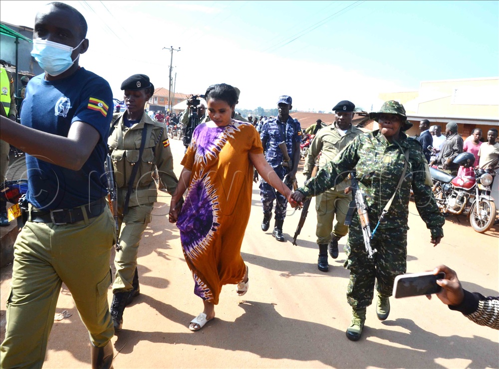 Rose Tusiime alias Doctor (Centre) being taken for a scene reconstruction in Kibuli Zone B. (Photo by Stuart Yiga)