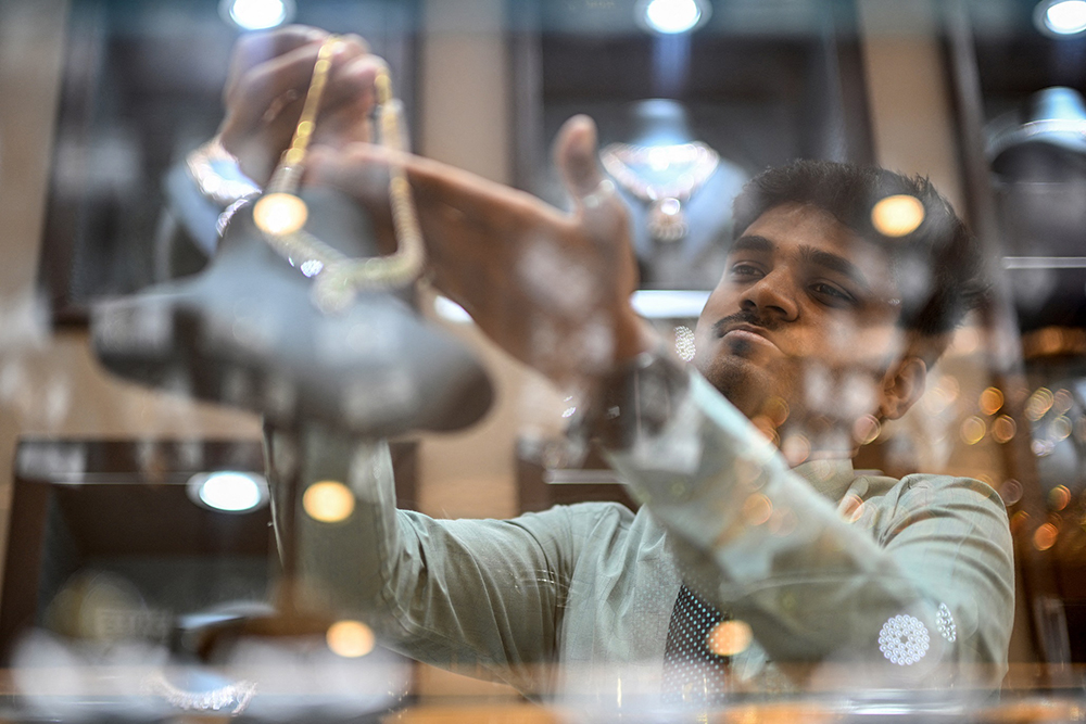 A salesman shows a diamond necklace at a jewellery store in Chennai on August 12, 2025.